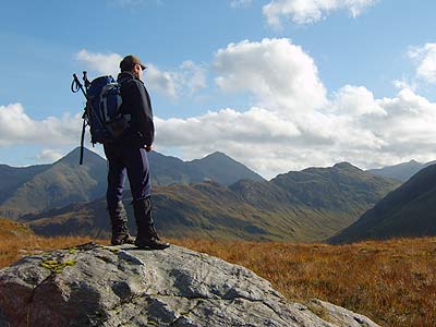 Trekking in Lochalsh - a walker on the summit of a mountain in Lochalsh